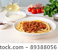 pasta bolognese with tomato sauce, ground minced beef, basil leaves on background 89388056