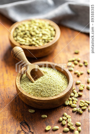 Ground green coffee and unroasted coffee beans in bowl. Ground green coffee and unroasted coffee beans in bowl. 89388385