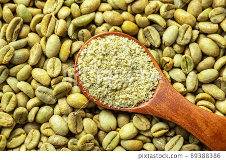 Ground green coffee in a scoop and unroasted coffee beans. Ground green coffee in a scoop and unroasted coffee beans. 89388386