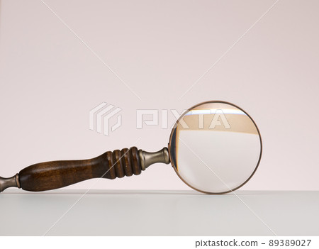 wooden magnifier on a white background. The concept of uncertainty and the search for solutions, doubts 89389027