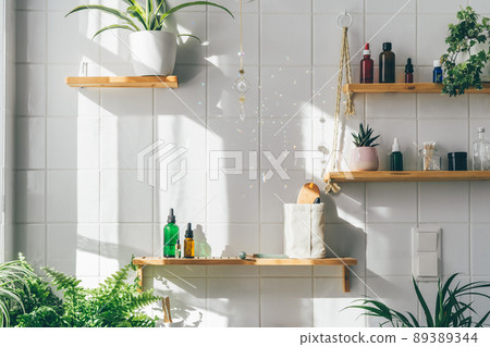 Biophilic desing in modern white bathroom with many green plants. Urban jungle. Natural materials, bamboo, wooden shalves. Shadows from sun light. Wellness and well-being Biophilic desing in modern white bathroom with many green plants. Urban jungle. Natural materials, bamboo, wooden shalves. Shadows from sun light. Wellness and well-being 89389344