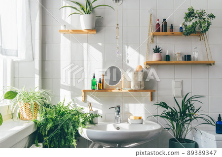 White modern bathroom in eco friendly stile. Shadows from the window on th tile wall at sunny day. Zero waste, eco friendly products, sustainability. Urban jungle. Biophilic design of interior 89389347