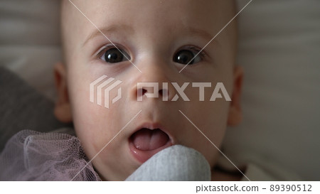 Close-up Happy playful kid 6 month old. Newborn boy looking at camera after bath shower on white soft bed. baby child waking time before bedtime with Toy. Childhood, motherhood, family, infant concept 89390512