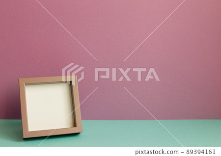 Blank picture frame on mint green table. pink wall background. copy space Blank picture frame on mint green table. pink wall background. copy space 89394161