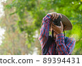 Asian man holding a camera with both hands.man wearing a hat taking pictures,copy space 89394431