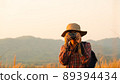Asian man holding a camera with both hands.man wearing a hat taking pictures,copy space 89394434