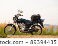 Black retro motorcycle with backpack parked outdoors. 89394435