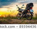 Black retro motorcycle with backpack parked outdoors. 89394436