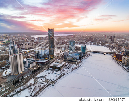 Yekaterinburg aerial panoramic view in Winter at beautiful pink and orange sunset. Yekaterinburg city and pond in winter. Yekaterinburg aerial panoramic view in Winter at beautiful pink and orange sunset. Yekaterinburg city and pond in winter. 89395671