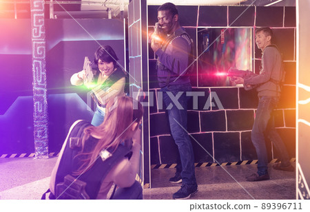 Modern people of different nationalities with laser pistols play 89396711