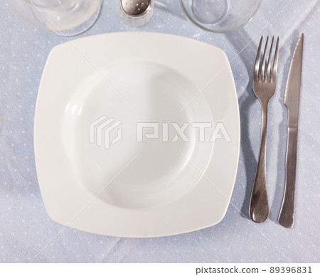 Empty plate and serving pieces on table Empty plate and serving pieces on table 89396831