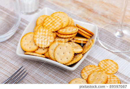 Crispy disc-shaped lightly salted crackers in plate on table 89397087