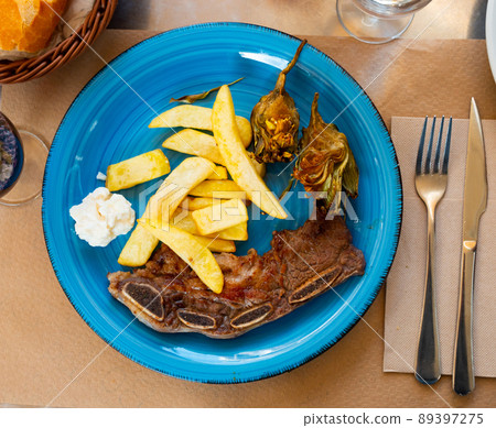 Portion of just cooked churrasco with potatoes and artichokes 89397275