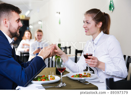 Elegant female and her boyfriend are celebrating date for dinner Elegant female and her boyfriend are celebrating date for dinner 89397379