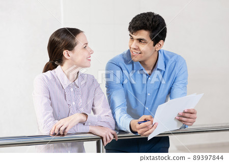 young woman and colleague discuss document young woman and colleague discuss document 89397844