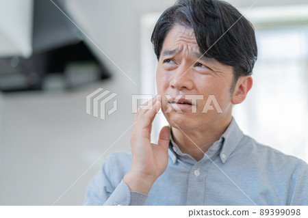 Middle-aged man complaining of toothache 89399098