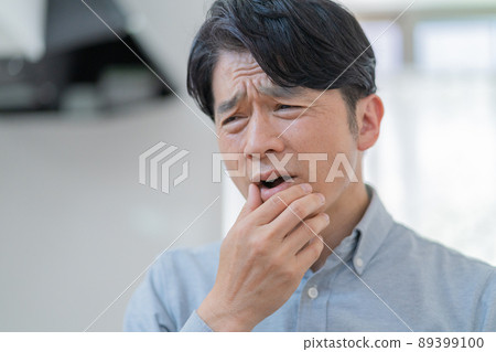 Middle-aged man complaining of toothache Middle-aged man complaining of toothache 89399100