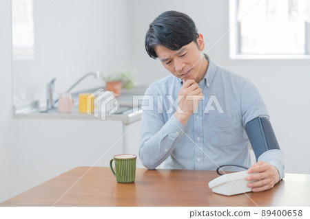 中年男子在客廳用血壓計測量血壓 89400658