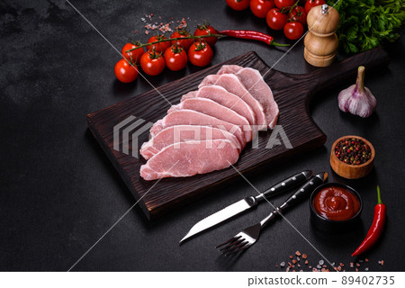Raw fresh pork meat sliced on a wooden cutting board 89402735
