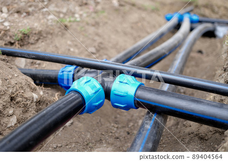 Connection of plastic sewer pipes closeup. Irrigation system for vegetable garden concept Connection of plastic sewer pipes closeup. Irrigation system for vegetable garden concept 89404564