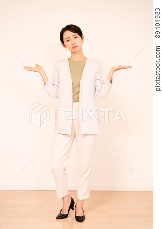 站在白牆前的年輕女商人 89404983
