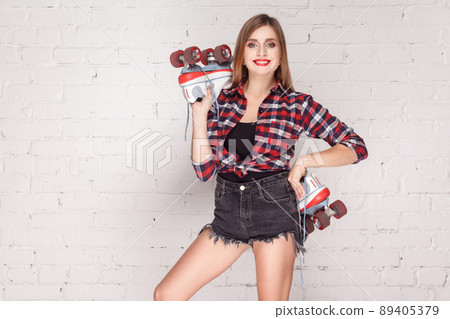Sexy woman toothy smiling at camera and holding quads. Indoor shot 89405379