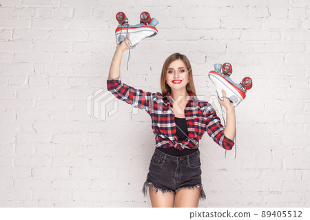Hands up! Hipster woman demonstrate quads and toothy smile. Studio shot 89405512