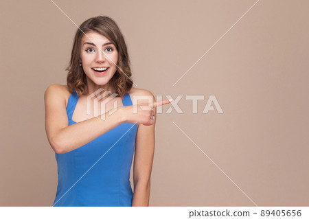 Amazement businesswoman pointing finger at copy space with shocked face. Studio shot 89405656