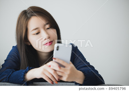 A woman watching a smartphone 89405796