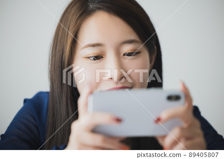 A woman watching a smartphone A woman watching a smartphone 89405807