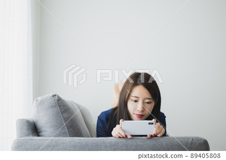 A woman watching a smartphone A woman watching a smartphone 89405808