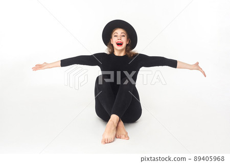 Happiness beautiful woman in hat, sitting on floor. Studio shot, isolated on white background Happiness beautiful woman in hat, sitting on floor. Studio shot, isolated on white background 89405968