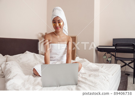 Asian young woman using notebook after shower at home 89406738