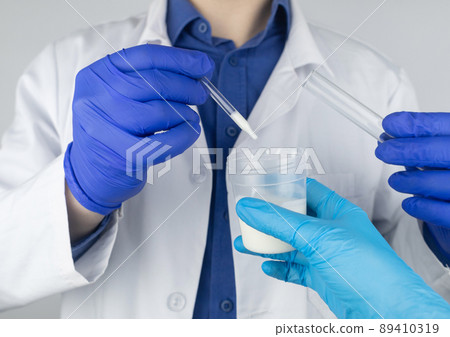 Medical laboratory assistant checks a test tube with sperm. Spermogram. Male fertility test. Semen in a test tube. Reproductive system check. Donor suitability test for artificial insemination 89410319
