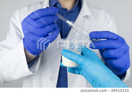 Medical laboratory assistant checks a test tube with sperm. Spermogram. Male fertility test. Semen in a test tube. Reproductive system check. Donor suitability test for artificial insemination Medical laboratory assistant checks a test tube with sperm. Spermogram. Male fertility test. Semen in a test tube. Reproductive system check. Donor suitability test for artificial insemination 89410320