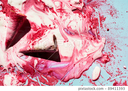 Melting raspberry ice-cream. Top view of empty waffle cones and melted ice-cream with pink powder creating beautiful patterns Melting raspberry ice-cream. Top view of empty waffle cones and melted ice-cream with pink powder creating beautiful patterns 89411393