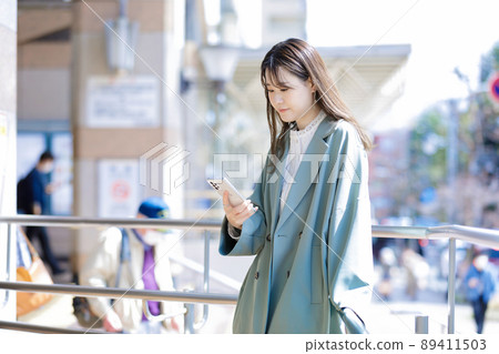 在城裡使用智能手機的年輕女子 89411503