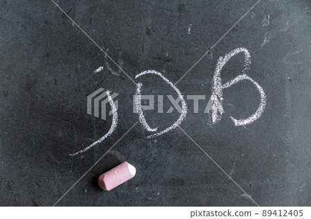 The word JOB is written on a black surface. Handwritten text in pink chalk on a dirty school blackboard. The word JOB is written on a black surface. Handwritten text in pink chalk on a dirty school blackboard. 89412405