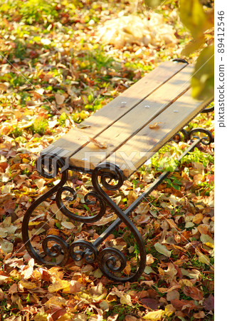 Industry making a forging bench in the fall in the garden in the foliage under the tree. Autumn garden background Industry making a forging bench in the fall in the garden in the foliage under the tree. Autumn garden background 89412546