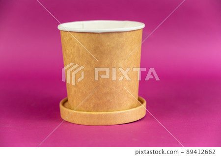 Empty cylindrical paper container with lid opposite-colored background. Brown food container for soup, ice cream, noodles, or other food. Empty cylindrical paper container with lid opposite-colored background. Brown food container for soup, ice cream, noodles, or other food. 89412662