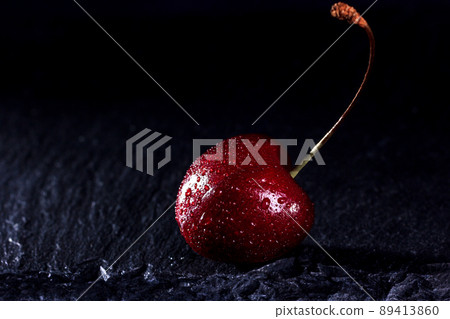 Sweet fresh red cherries on black stone background. Black background with space for text. Drops of water on the berries. Sweet fresh red cherries on black stone background. Black background with space for text. Drops of water on the berries. 89413860