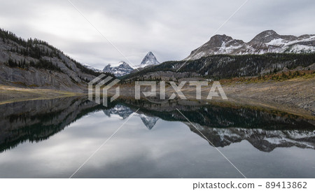 Prominent mountain reflecting in alpine lake during overcast day, Pano, Mt Assiniboine PP, Canada 89413862