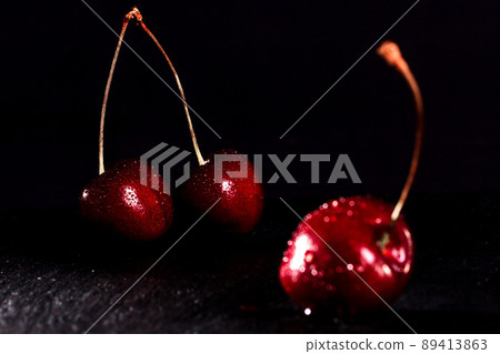 red cherries with water drops on black stone stand on a black background red cherries with water drops on black stone stand on a black background 89413863