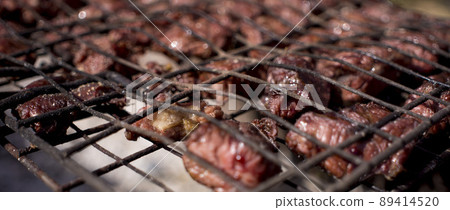 meat is fried on the grill over the coals 89414520