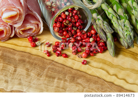Fresh Young Asparagus with raw bacon ready for cooking. Asparagus and bacon on wood board with red pepper peas. Fresh Young Asparagus with raw bacon ready for cooking. Asparagus and bacon on wood board with red pepper peas. 89414673