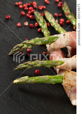 Asparagus with bacon served on black stone. healthy food - breakfast. dark food background. Asparagus with bacon served on black stone. healthy food - breakfast. dark food background. 89414675