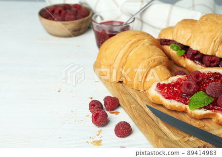 Concept of delicious food with croissants with raspberry jam on white wooden background Concept of delicious food with croissants with raspberry jam on white wooden background 89414983