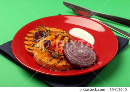 Concept of tasty food with baked pumpkin on green background 89415040