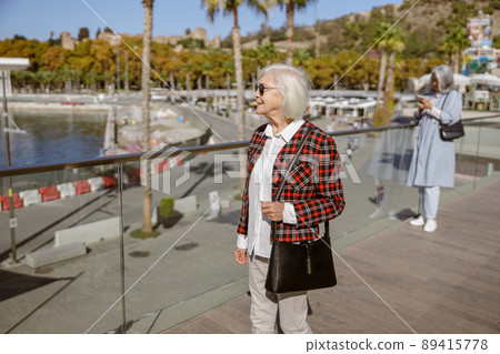 Cute older lady walking in day time outdoors 89415778