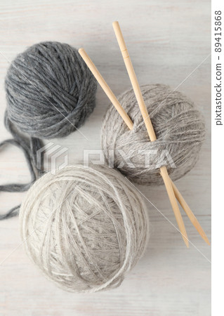 Balls of yarn with knitting needles on white wooden background Balls of yarn with knitting needles on white wooden background 89415868
